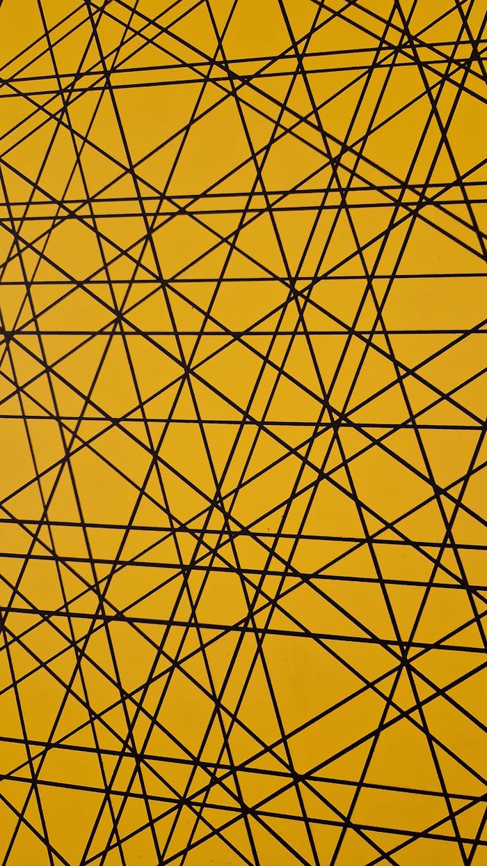 Dynamic abstract pattern of black geometric lines intersecting on a vibrant yellow background.